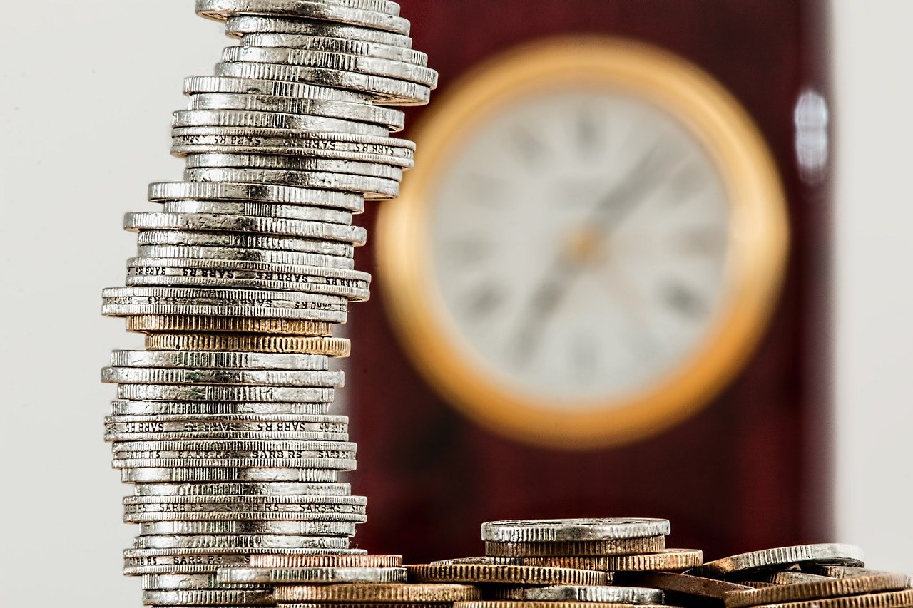 coins and a clock symbolizing time and money you will create with our accounting services